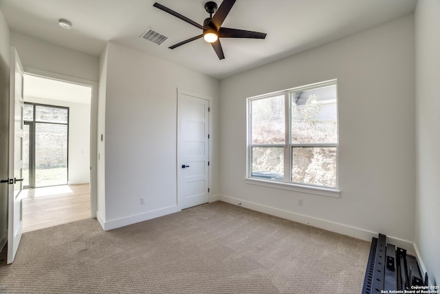 unfurnished bedroom featuring baseboards, visible vents, ceiling fan, and carpet flooring