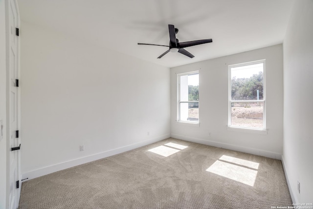 carpeted spare room with baseboards and a ceiling fan