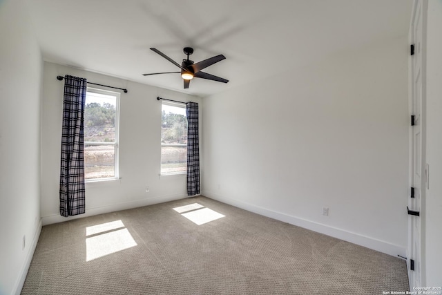 carpeted empty room with baseboards and a ceiling fan