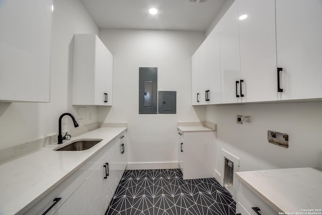 laundry room featuring electric panel, a sink, hookup for an electric dryer, and baseboards