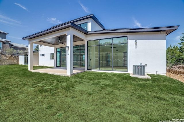 rear view of house with a patio, central AC, and a yard