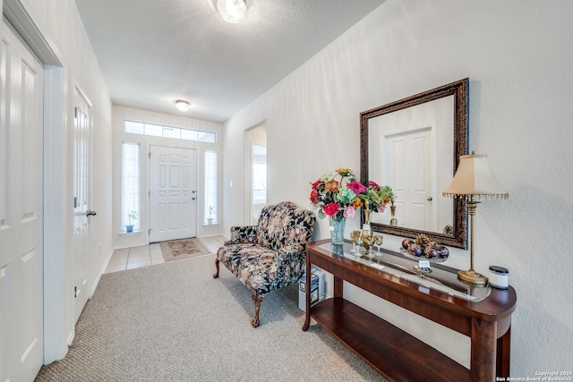 foyer entrance with carpet floors and tile patterned flooring