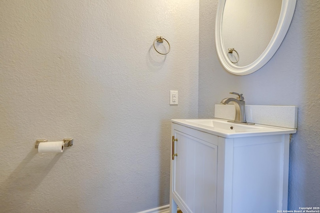 bathroom featuring a textured wall and vanity