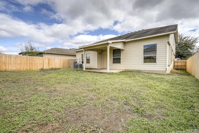 rear view of property featuring a fenced backyard, central AC unit, a patio, and a yard