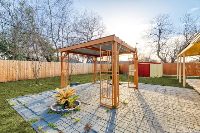 view of patio / terrace with an outbuilding, a fenced backyard, and a shed