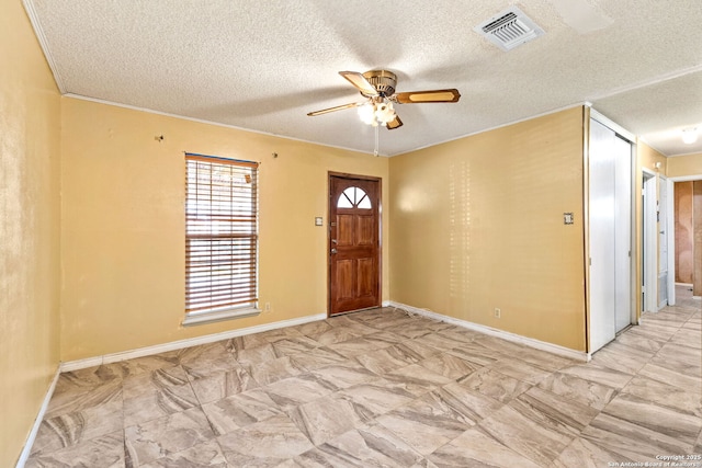 foyer with ceiling fan, a textured ceiling, visible vents, and baseboards