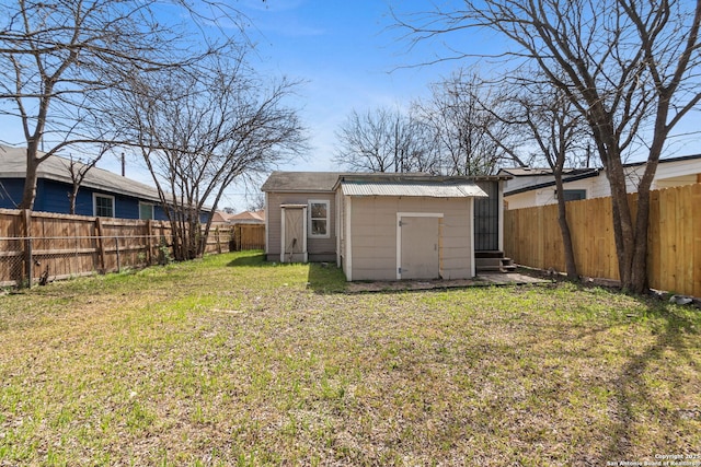 view of yard with a shed, a fenced backyard, and an outdoor structure