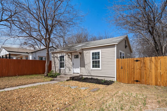 bungalow-style home with fence