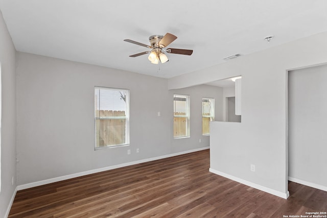 empty room with a ceiling fan, baseboards, and wood finished floors