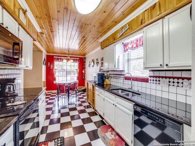 kitchen featuring dark floors, tasteful backsplash, ornamental molding, a sink, and black appliances