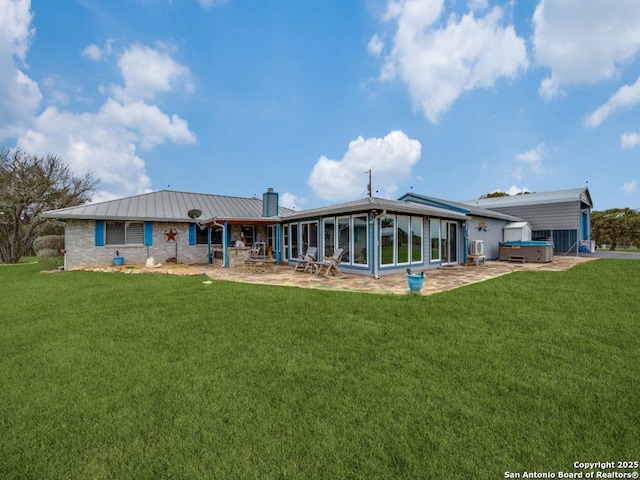 back of property featuring a yard, metal roof, a patio, and a hot tub