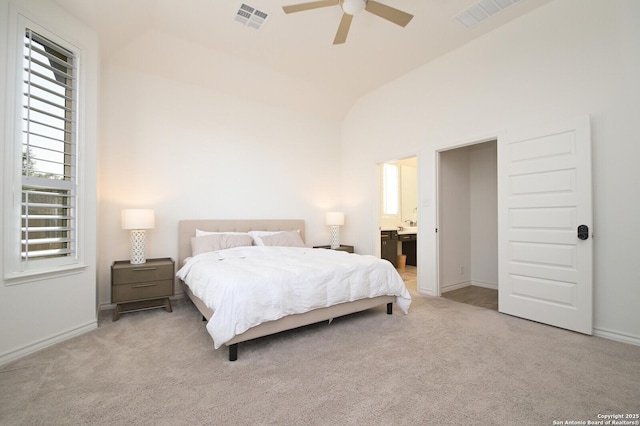 carpeted bedroom featuring lofted ceiling, visible vents, baseboards, and ensuite bathroom