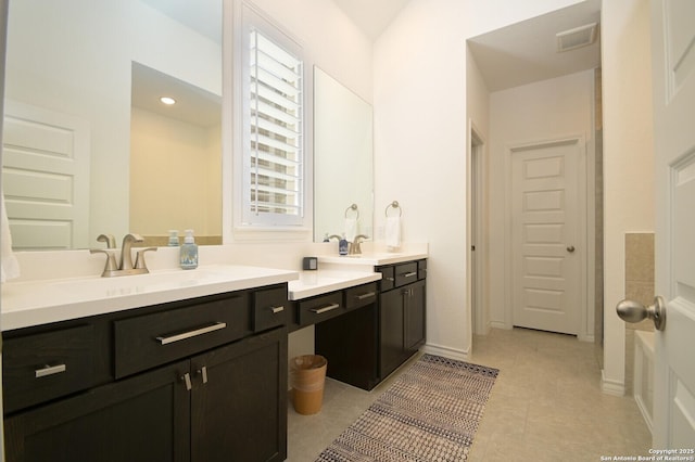 full bathroom with double vanity, visible vents, a sink, tile patterned flooring, and baseboards