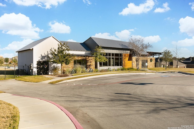 view of building exterior featuring uncovered parking and fence