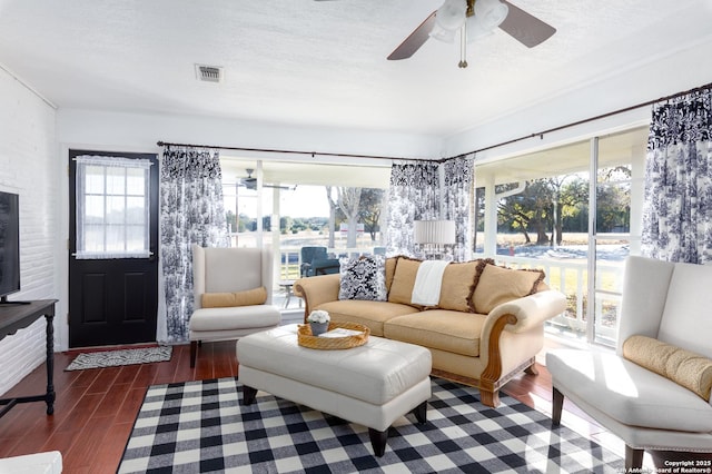 living room featuring visible vents, ceiling fan, a textured ceiling, and wood finished floors