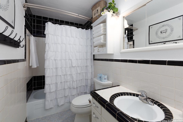 full bath featuring toilet, a wainscoted wall, tile walls, and shower / tub combo with curtain