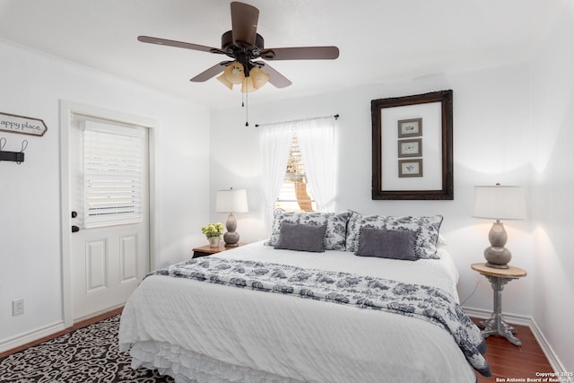 bedroom with a ceiling fan, baseboards, and wood finished floors