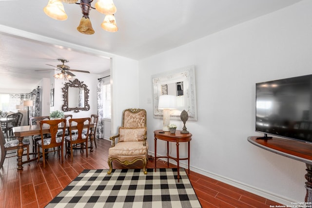 dining room featuring ceiling fan with notable chandelier, wood finish floors, and baseboards