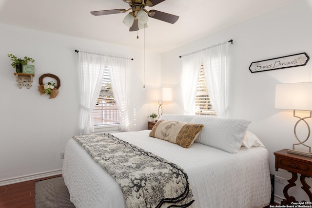 bedroom featuring a ceiling fan, baseboards, and wood finished floors