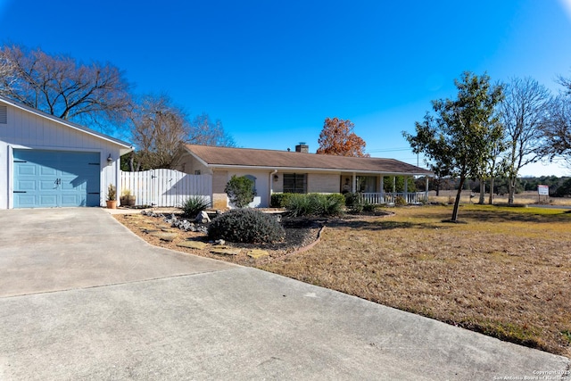 ranch-style home with concrete driveway, a chimney, a gate, fence, and a front yard