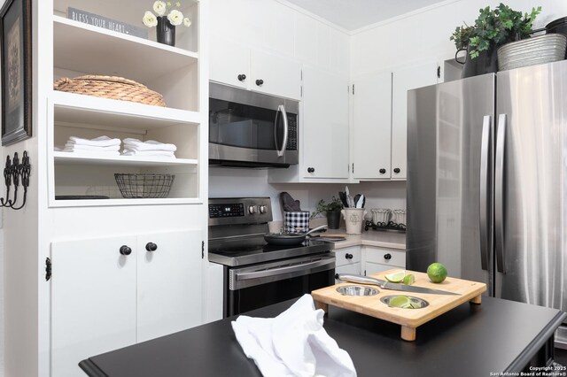 kitchen featuring white cabinets, appliances with stainless steel finishes, light countertops, crown molding, and open shelves