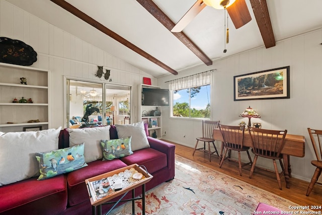 living room featuring ceiling fan, lofted ceiling with beams, and wood finished floors