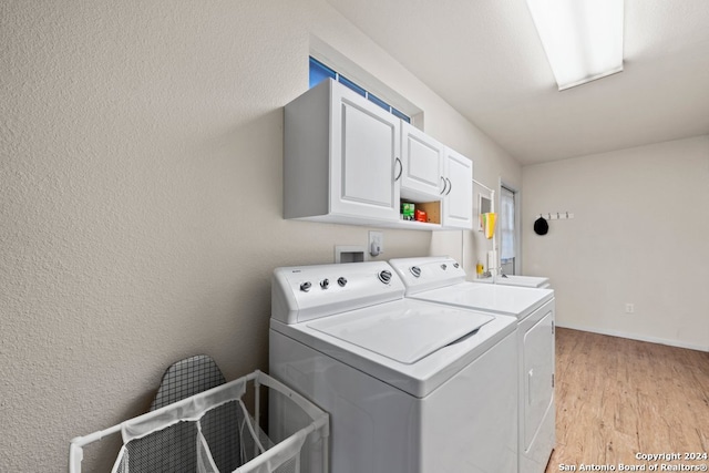 laundry area with light wood-style flooring, washing machine and clothes dryer, cabinet space, and baseboards