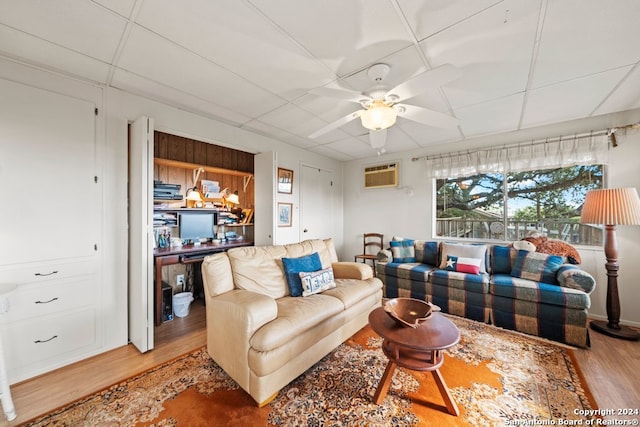 living area with ceiling fan, wood finished floors, and a wall mounted air conditioner