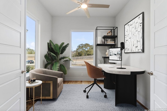 home office featuring wood finished floors, a ceiling fan, and baseboards