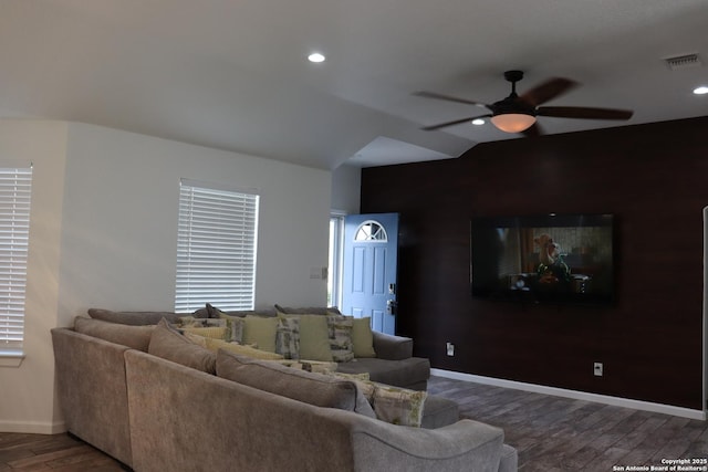 living area with visible vents, ceiling fan, baseboards, and wood finished floors