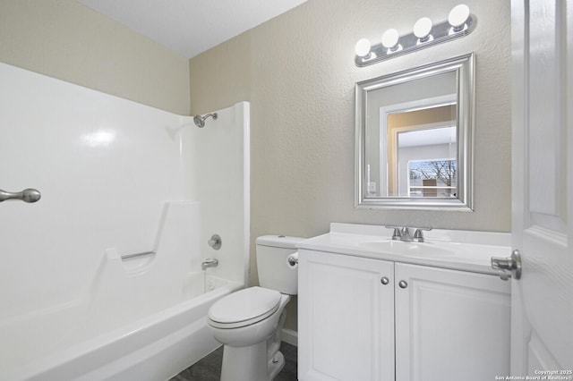 bathroom featuring toilet, a textured wall, tub / shower combination, and vanity