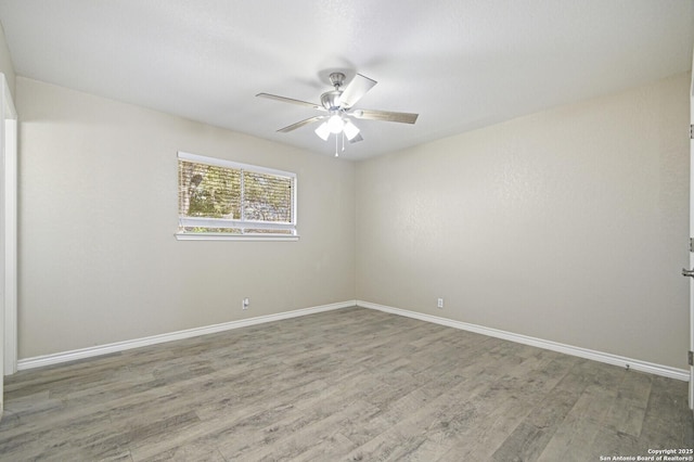 unfurnished room with ceiling fan, baseboards, and wood finished floors