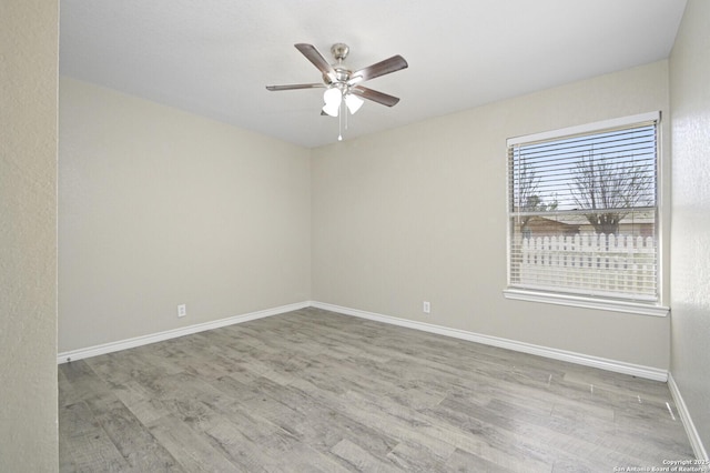 unfurnished room with ceiling fan, baseboards, and wood finished floors