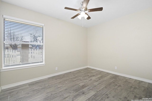 empty room with a ceiling fan, baseboards, and wood finished floors