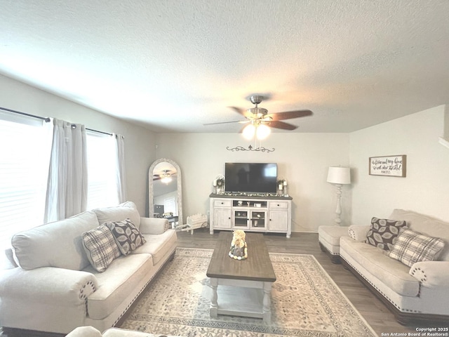 living area featuring a textured ceiling, wood finished floors, and a ceiling fan