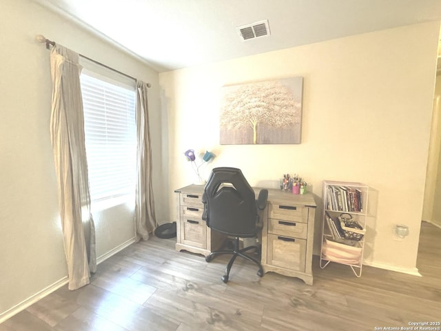 home office featuring visible vents, baseboards, and wood finished floors
