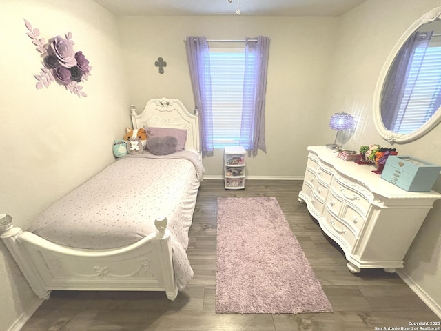 bedroom with dark wood finished floors and baseboards