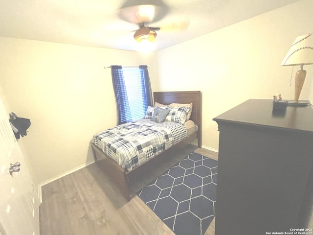 bedroom with a ceiling fan and baseboards