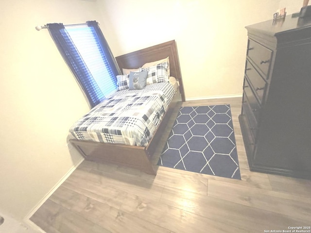 bedroom with wood finished floors and baseboards