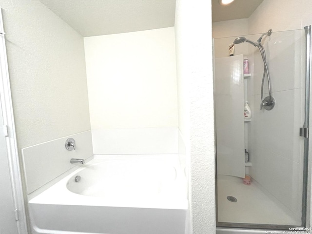 full bathroom with a shower stall and a bath