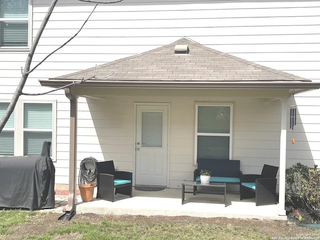 back of property with a patio area, outdoor lounge area, and roof with shingles