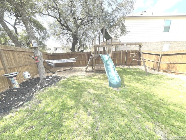 view of yard featuring a playground and a fenced backyard