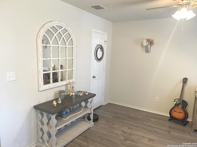 foyer featuring dark wood-style flooring, visible vents, ceiling fan, and baseboards