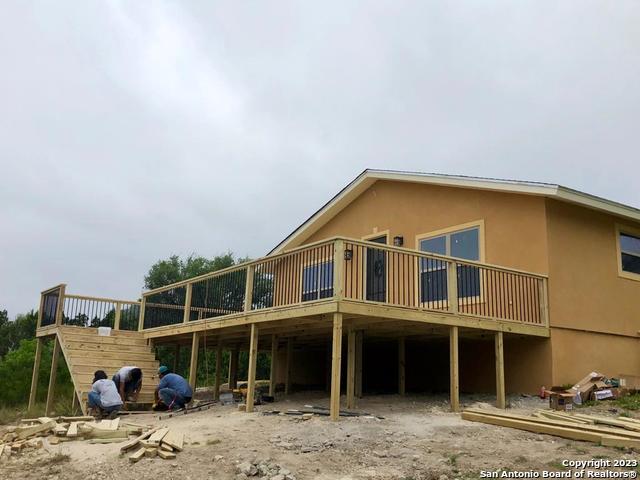 back of property with a carport and a wooden deck