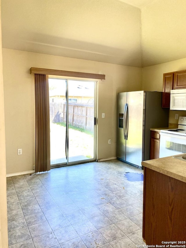 kitchen featuring white appliances, light countertops, and baseboards