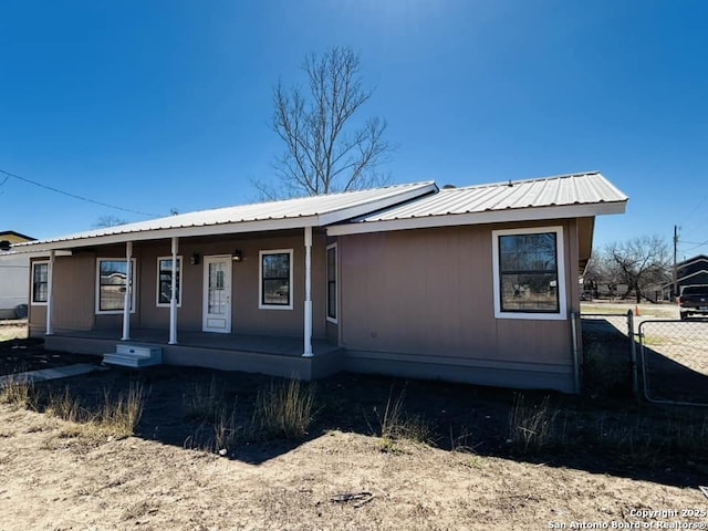 view of front of property with metal roof, a porch, and fence