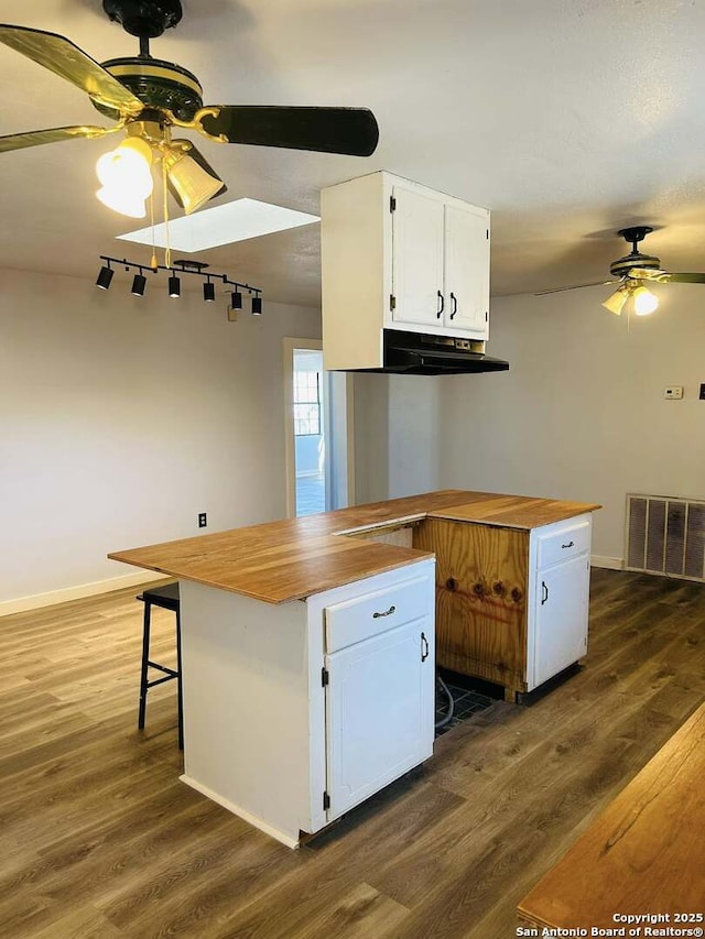 kitchen with visible vents, white cabinets, ceiling fan, butcher block counters, and dark wood-type flooring