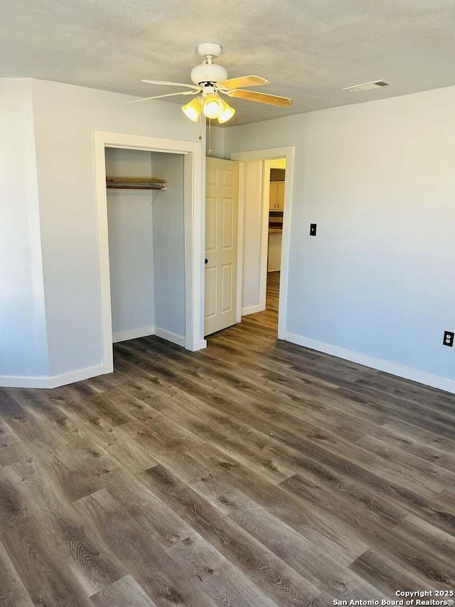 unfurnished bedroom with baseboards, visible vents, and dark wood-style flooring