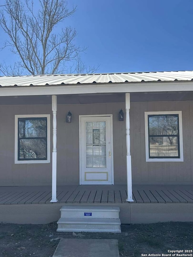 entrance to property featuring metal roof and a porch