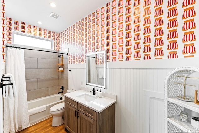 bathroom featuring visible vents, wainscoting, toilet, wood finished floors, and vanity